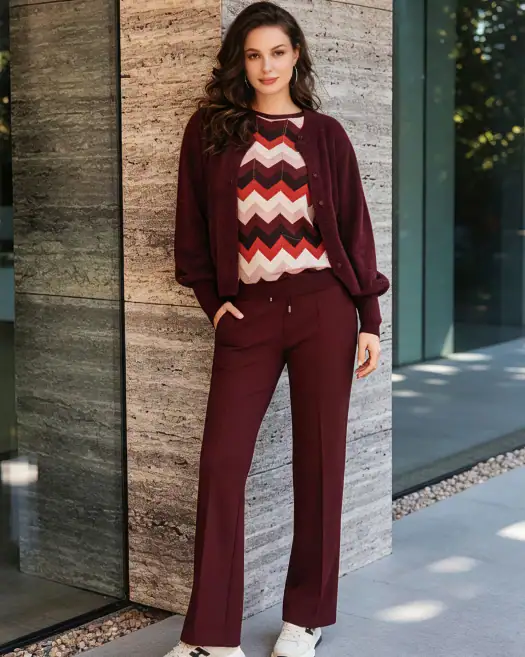 Elegant burgundy women's suit featuring a patterned top, matching trousers, and a cozy cardigan, perfect for professional or casual wear.