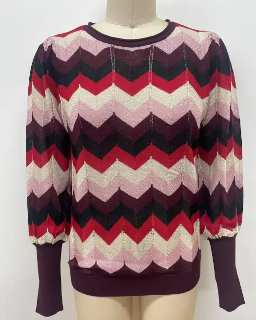 Vibrant chevron pattern sweater with long sleeves, featuring shades of pink, red, black, and cream, perfect for casual or office wear.