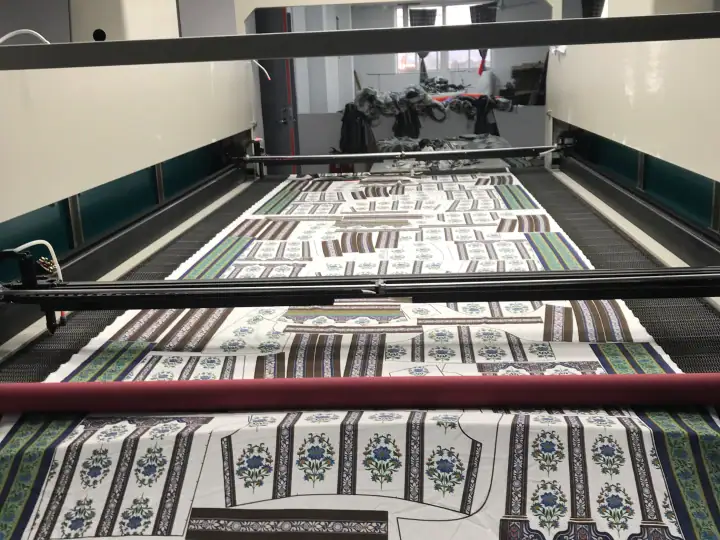 Industrial textile printing machine producing patterned fabrics with intricate designs and vibrant colors.