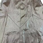 Close-up of a shiny metallic leather skirt with geometric paneling, perfect for stylish and modern fashion looks.