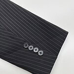 Close-up of a black pinstripe suit sleeve with four buttons, showcasing professional men's fashion and tailored clothing.