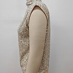 Close-up of a sleeveless women's top covered in shimmering sequins, displayed on a mannequin against a plain background.