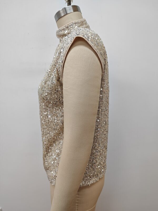 Close-up of a sleeveless women's top covered in shimmering sequins, displayed on a mannequin against a plain background.