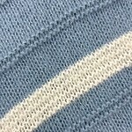 Detailed close-up of blue knitted fabric with a white stripe, showcasing the texture and weave of the material, ideal for fashion and textile SEO.