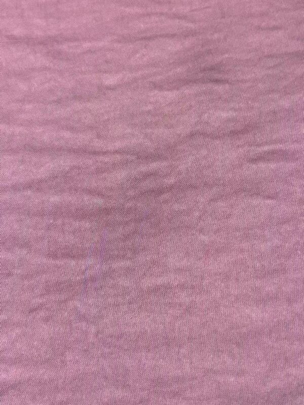 Close-up of pink fabric with soft texture, suitable for fashion and clothing design.