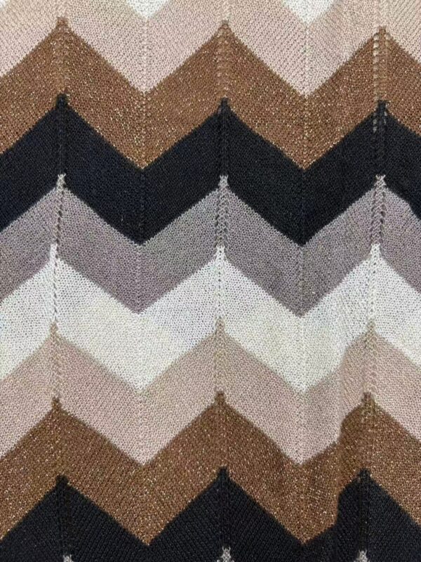 Close-up of chevron knit fabric in shades of brown, black, gray, and white, showcasing textured pattern and intricate stitching.