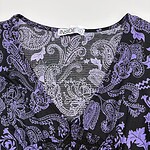 Close-up of a purple floral dress with intricate paisley and leaf patterns, perfect for stylish occasions and summer wear.