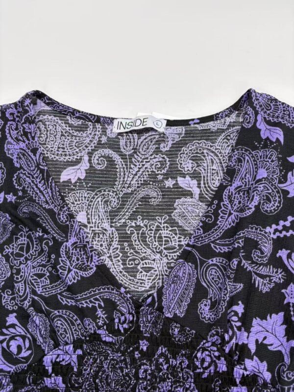 Close-up of a purple floral dress with intricate paisley and leaf patterns, perfect for stylish occasions and summer wear.