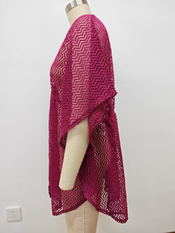 Bright pink crochet cover-up with zigzag pattern, perfect for beachwear or summer fashion, displayed on a mannequin against a plain white background.