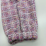 Close-up of vibrant pink, yellow, and white tweed fabric with a textured pattern, suitable for stylish clothing and accessories.