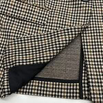 Close-up of a classic houndstooth blazer showing detailed fabric pattern and inner pocket lining, perfect for stylish men's fashion.