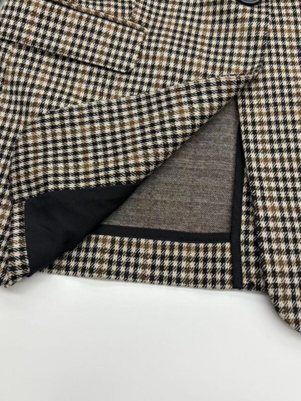 Close-up of a classic houndstooth blazer showing detailed fabric pattern and inner pocket lining, perfect for stylish men's fashion.