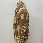 Brown knit sweater with cream floral patterns, long sleeves, and a high collar, perfect for fall and winter fashion.