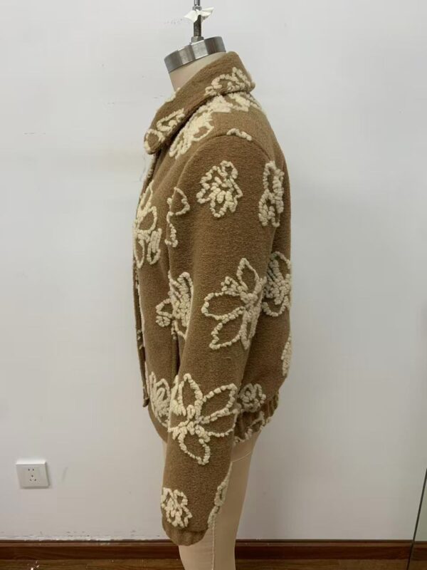 Brown knit sweater with cream floral patterns, long sleeves, and a high collar, perfect for fall and winter fashion.