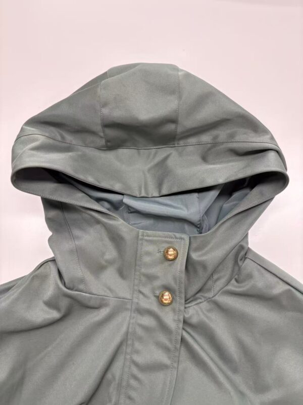 Elegant grey hooded raincoat with gold button details, perfect for rainy days and outdoor fashion.
