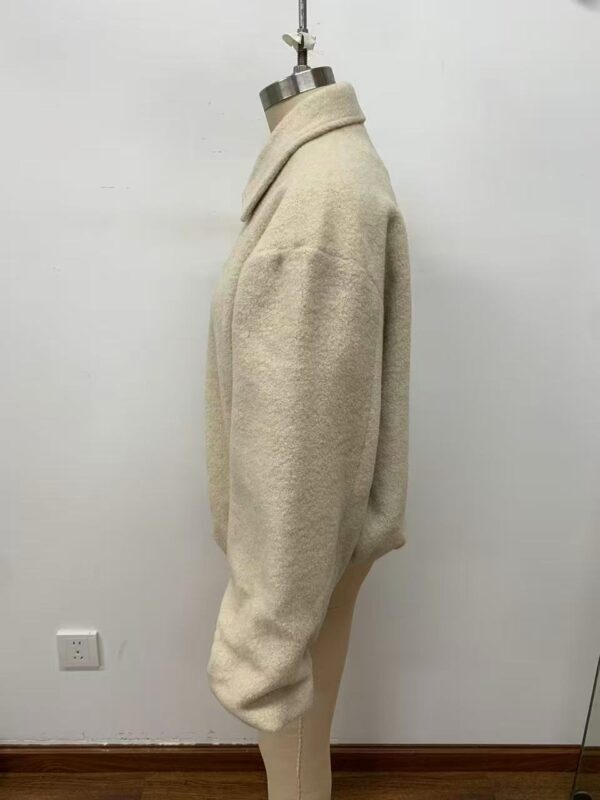 Elegant beige wool coat displayed on a mannequin, perfect for fall and winter fashion, showcasing a classic and timeless style.