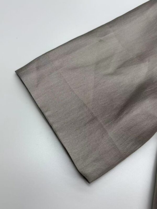 Close-up of smooth gray fabric, ideal for fashion and clothing design, showcasing fine texture and quality material.
