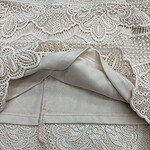 Close-up of intricate lace fabric with floral and geometric patterns, perfect for wedding dresses and elegant garments.