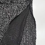 Close-up of a black sequin dress showing intricate sequin pattern and fabric texture for stylish evening wear.