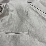 Close-up of a light gray men's dress shirt with a pocket and subtle fabric texture, suitable for formal or business wear.