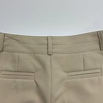 Close-up of beige women's dress pants with tailored fit and sleek design, perfect for professional or formal occasions.