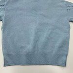Light blue women's knit sweater with distressed details on shoulders, crew neck, and ribbed hem, perfect for casual fashion and cozy wear.