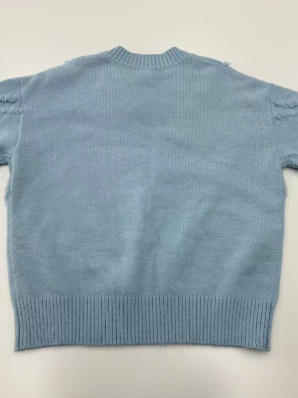 Light blue women's knit sweater with distressed details on shoulders, crew neck, and ribbed hem, perfect for casual fashion and cozy wear.