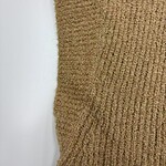 Close-up of a brown knitted sweater showcasing textured fabric and ribbed pattern, perfect for autumn and winter wear.