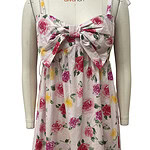 Elegant floral summer dress with a large bow on the front, featuring pink, yellow, and purple flowers on a white background, perfect for warm weather and casual outings.