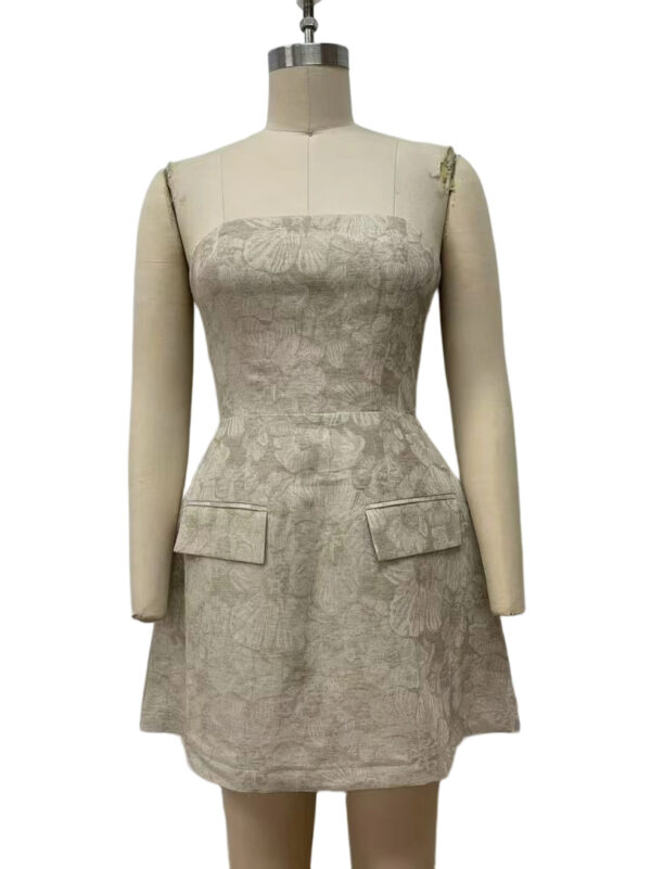 Elegant beige floral dress with long sleeves and a fitted bodice, featuring two front pockets and a subtle floral pattern, perfect for formal occasions.