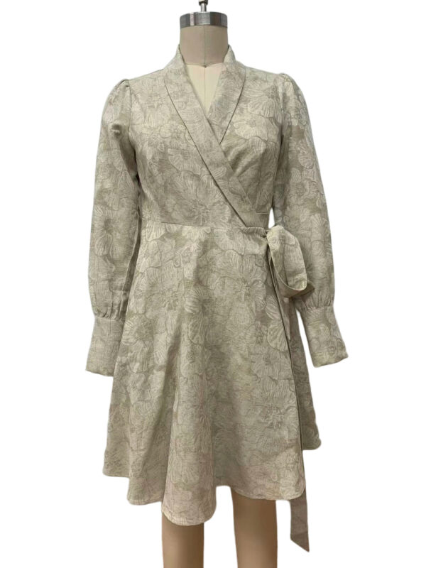 Elegant beige wrap dress with long sleeves and floral pattern, featuring a waist tie, displayed on a mannequin for fashion showcase.