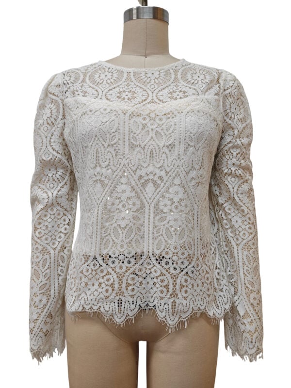 Elegant white lace blouse with intricate patterns, long sleeves, and scalloped hem, perfect for formal or special occasions.