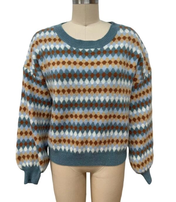 Women's cozy sweater with a multicolored geometric pattern in shades of blue, brown, white, and beige, featuring a round neckline and long sleeves.