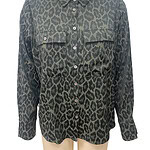 Stylish women's button-up shirt with a bold leopard print pattern, long sleeves, and chest pockets, perfect for casual or chic outfits.
