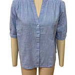 Light blue linen blouse with a V-neck, button-down front, and rolled-up sleeves, perfect for casual or office wear.