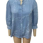Light blue women's blouse with white floral embroidery, button-up front, and three-quarter sleeves, perfect for casual or semi-formal wear.