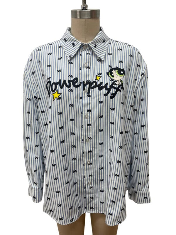 Stylish women's button-down shirt with playful cartoon character and text design, featuring vertical stripes and small bow motifs, perfect for casual wear.