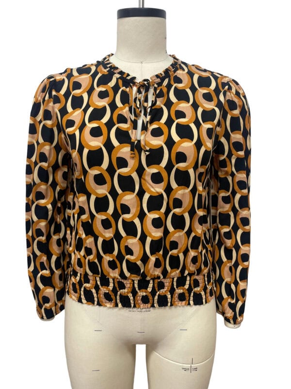 Stylish women's blouse with a bold geometric pattern in black, beige, and brown, featuring a round neckline with a tie detail and elasticized hem for a comfortable fit.