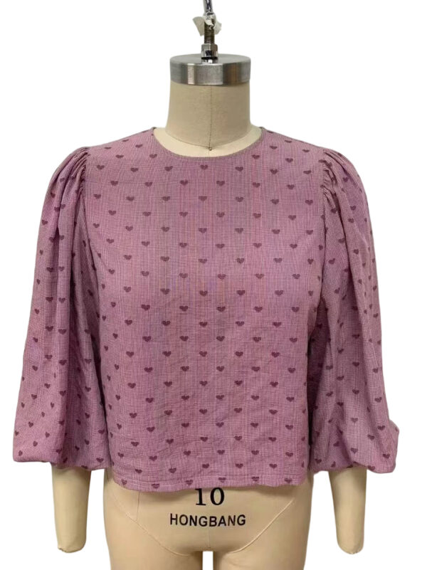 Pink women's blouse with small heart patterns, puffed three-quarter sleeves, and a round neckline, ideal for casual or semi-formal wear.