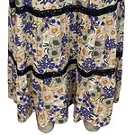 Elegant floral maxi skirt with a colorful pattern of blue, yellow, and gray flowers, featuring black lace accents and a comfortable elastic waistband.