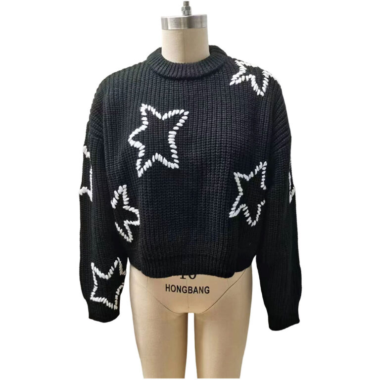 Black knit sweater with white star patterns, oversized fit, and ribbed cuffs and neckline, displayed on a mannequin for fashion showcase.