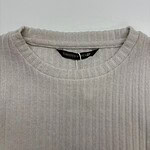 Close-up of a beige ribbed sweater with a round neckline, perfect for casual and stylish wear.