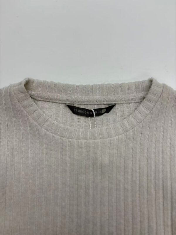 Close-up of a beige ribbed sweater with a round neckline, perfect for casual and stylish wear.