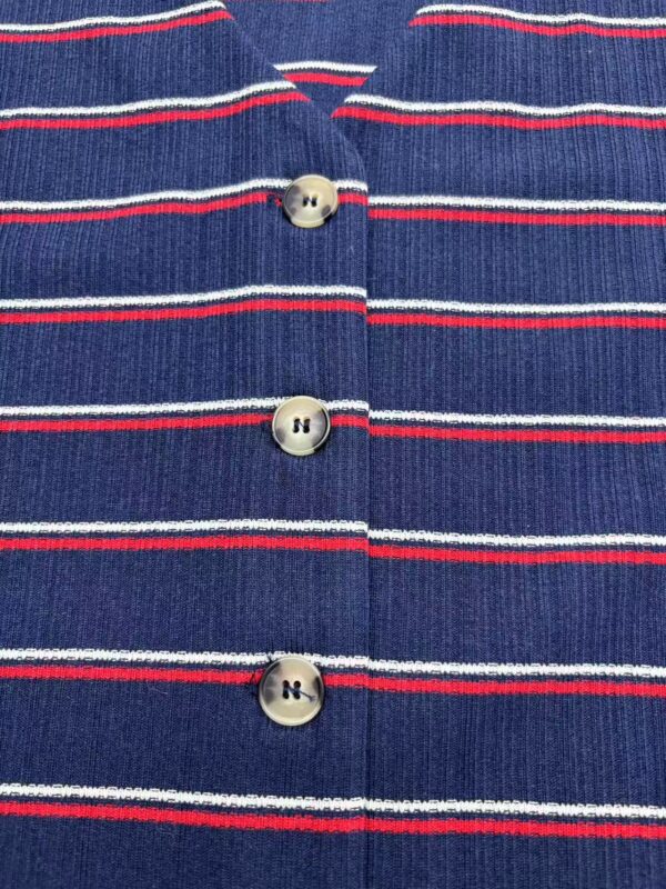 Close-up of a blue knitted cardigan with red and white horizontal stripes and four buttons down the front.