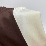 Close-up of fabric with brown and cream color blocks, showcasing smooth texture and clean lines, ideal for fashion and apparel design.