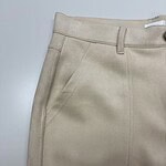 Close-up of a beige women's skirt featuring a high waist, front pocket, and tailored design, perfect for casual or office wear.
