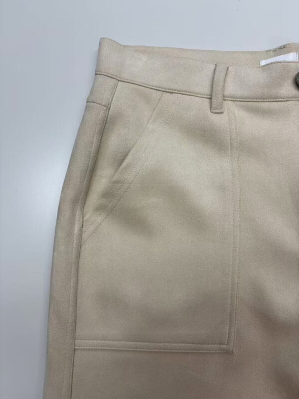 Close-up of a beige women's skirt featuring a high waist, front pocket, and tailored design, perfect for casual or office wear.