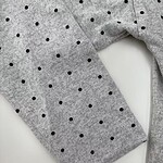 Close-up of a gray women's sweater with black polka dots, showcasing soft fabric and stylish design, ideal for casual or office wear.