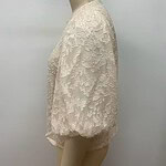 Cream-colored lace wedding top displayed on a mannequin, featuring intricate floral embroidery and a classic round neckline.