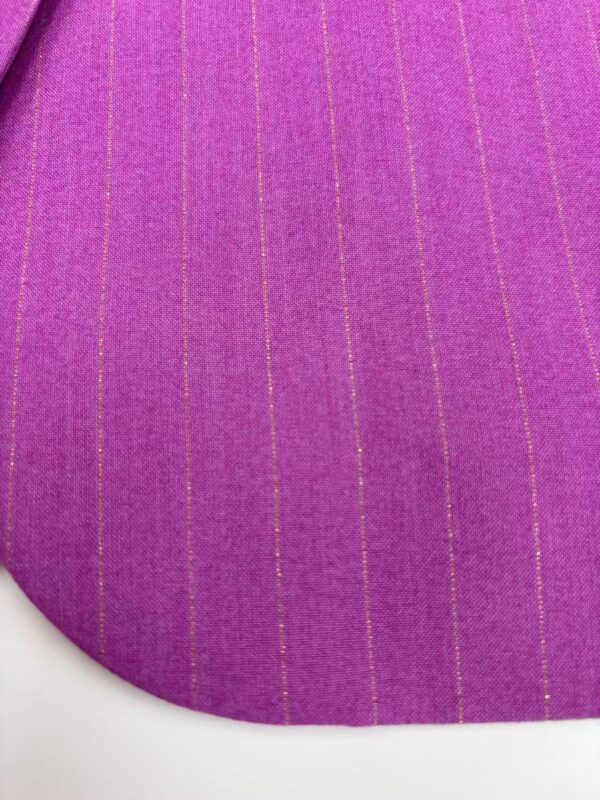 Close-up of vibrant pink fabric with thin yellow pinstripes, showcasing a smooth texture and fine weave, ideal for fashion and textile design.